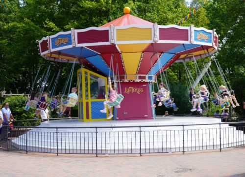 In dem Kinder-Kettenkarussell sitzen viele Kinder und genießen die Fahrt.