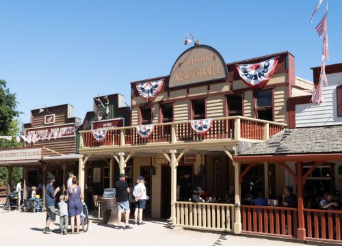 Das Gebäude des Saloon New Chance von außen. Auf der Terrasse sitzen Gäste und essen.