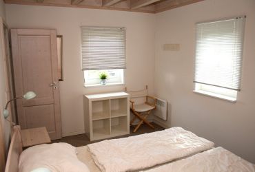 Doppelbeet mit Nachttisch. Ein kleines Regal mit steht zur Verfügung.