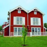 Ein Haus des Typus Hummer von außen. Es ist von außen rot gefärbt.