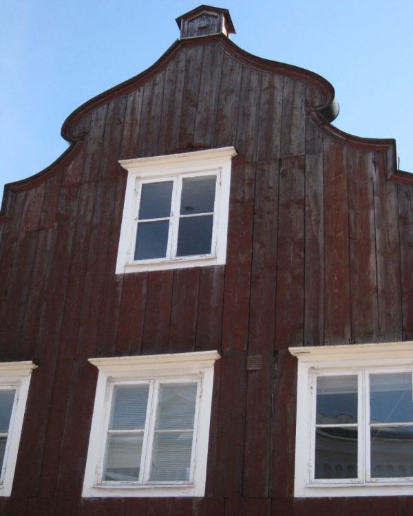 Der Giebel des Originalgebäude des Alten Gasthofes Visby. Er besteht aus Holz und hat weiße Fenster.