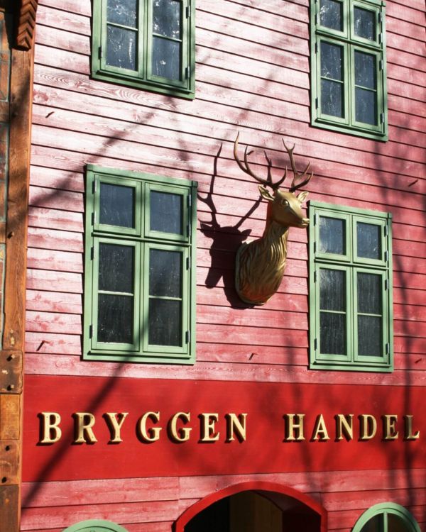 Das Gebäude Bryggen Handel aus Norwegen. Es hat einen goldenen Hirschkopf vorne befestigt.