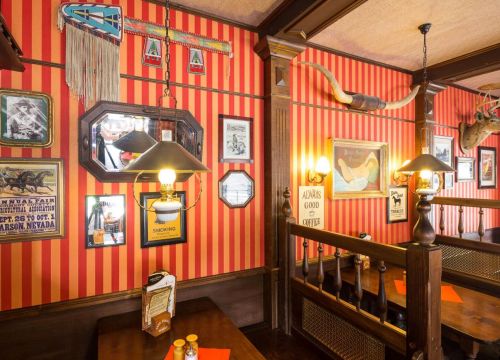 Die Tische im Saloon New Chance. Die Wände sind mit stilechter Deko dekoriert.