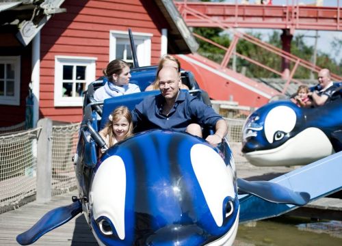 Die Attraktion Flying Orca mit zwei Orcars in denen Gästen sitzen und warten das es losgeht.