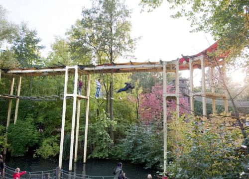 Im Hochseilgarten Navajo Trail gehen Gäste den Pfad entlang. Auf der Schwimmbrücke schauen Gäste zu.