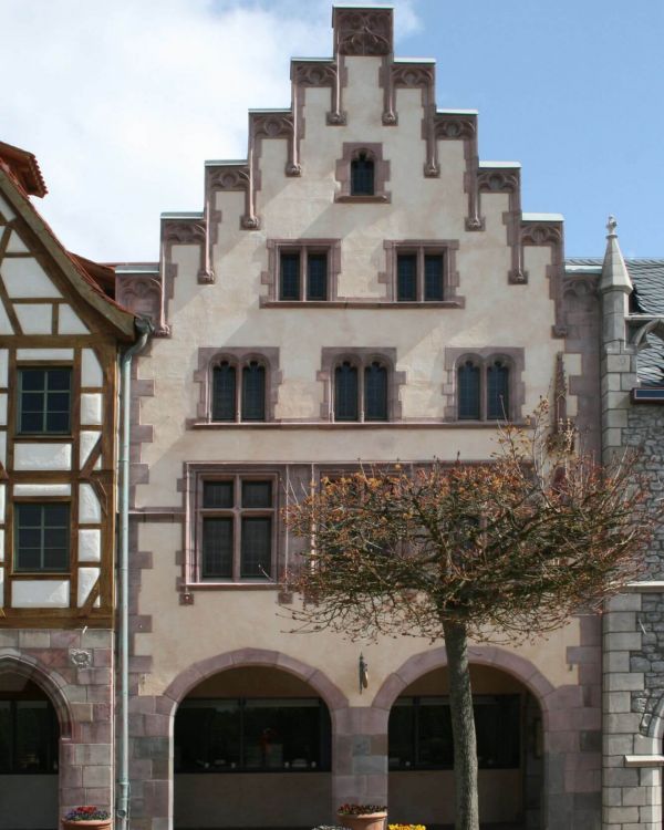 Die Weinstube im Römer aus Frankfurt am Main. Es ist ein rot, gelber Bau mit einem Stufengiebel.