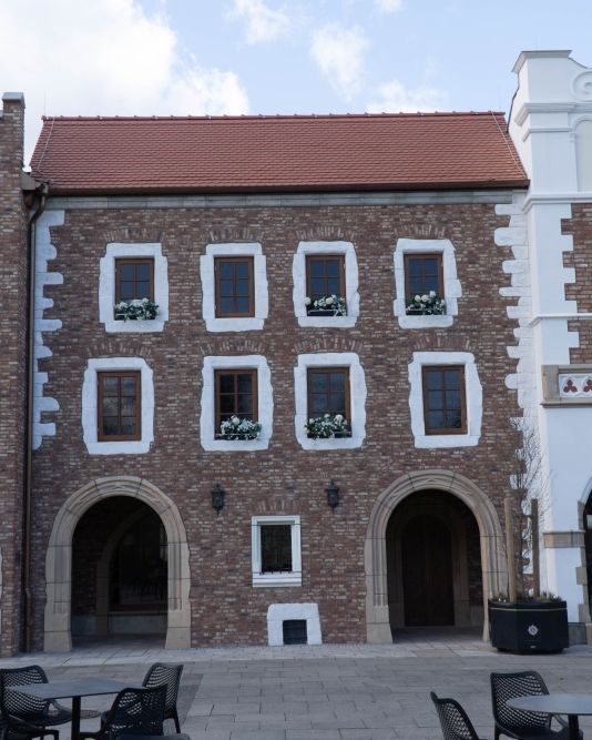Das Gebäude Muzeum Uniwersytetu Jagiellonskiego aus Polen. In den Fenstern sind kleine Blumenkästen.