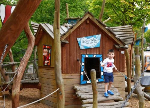Zwei Jungs am Kletterhaus des Niedrigseilgarten. Ein Junge ist am Fenster. Der andere draußen.