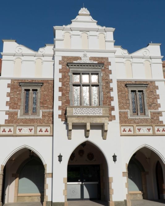 Das Gebäude Sukiennice aus Polen. Ein weißes Gebäude bei dem der mittlere Teil heraussticht.