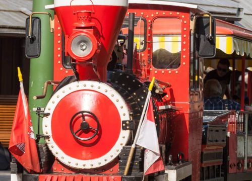 Die Lok des HANSA-PARK-Express von vorne. Im Hintergrund der Bahnhof Peterhof.