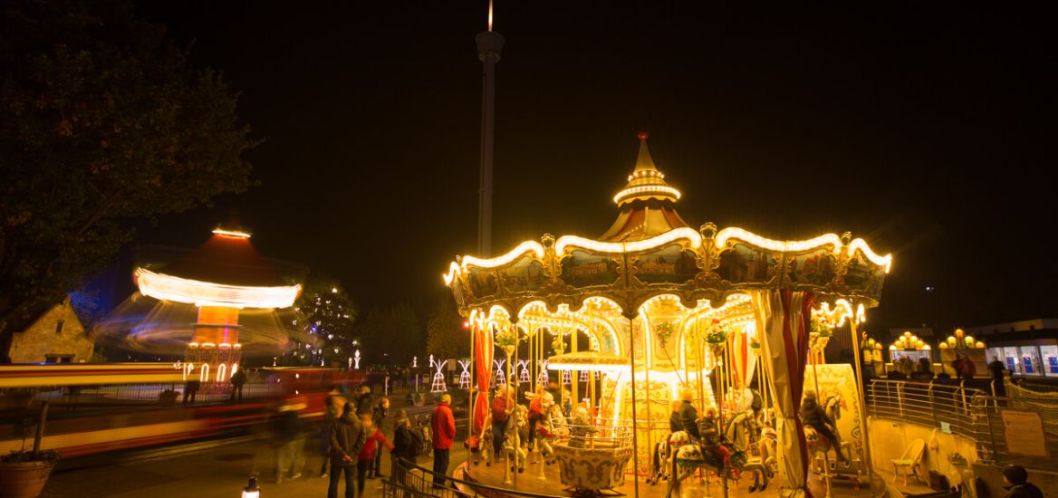 Der HANSA-PARK-Express, der HANSE-Flieger und das HANSE-Karussell ist erleuchtet und bewegen sich.