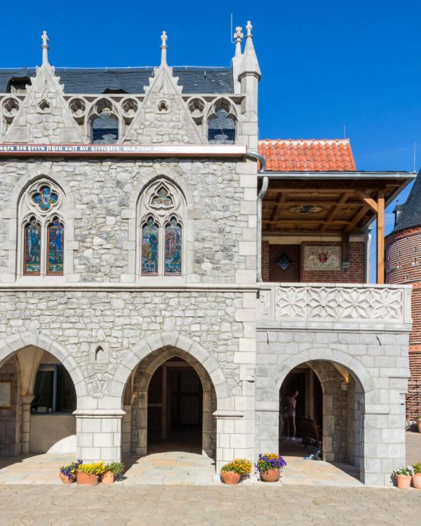 Das Rathaus von Goslar in Gänze von vorne. An den Säulen der Bögen stehen Blumentöpfe.