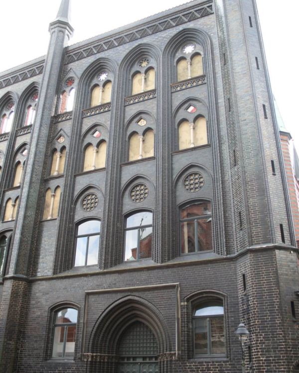 Das Originalgebäude des Lübecker Rathauses. Es hat ein kunstvolle, dunkle Schmuckfassade.