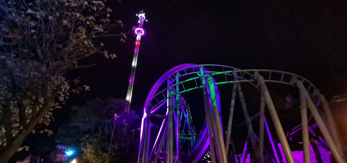 Looping der Achterbahn Nessi, Schiene des Royal Scotsman und Turm HIGHLANDER werden angestrahlt.