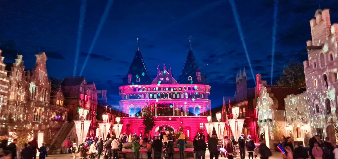 Das Holstentor des HANSA-PARKs wird rosa angestrahlt. Davor werden Seifenblasen versprüht.