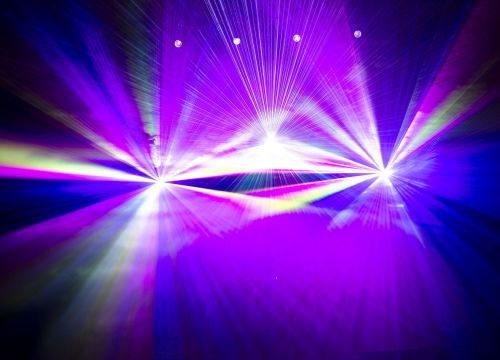 Im Nebel der Lasershow zeigen sich rosafarbene und weiße Laserstrahlen.