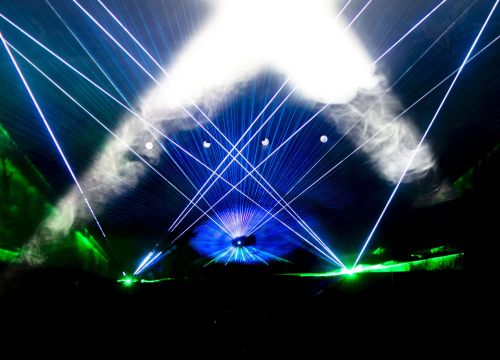 Im Nebel der Lasershow zeigen blaue und grüne Laserstrahlen von drei Punkten in die Luft.