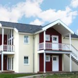 Das Haus vom Typ Auster von außen. Es ist von außen gelb und rot gefärbt.