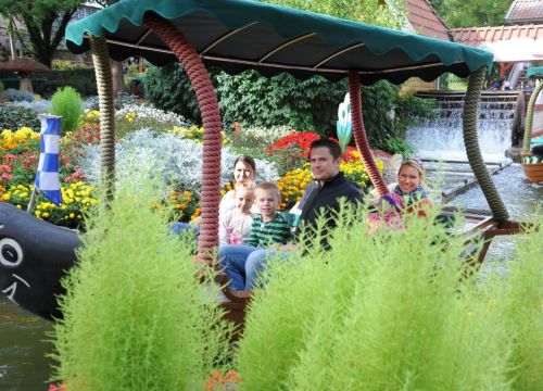 Eine Familie bestaunt die Vielfalt der verschiedenen Blumen in der Attraktion Blumenmeer-Bootsfahrt.