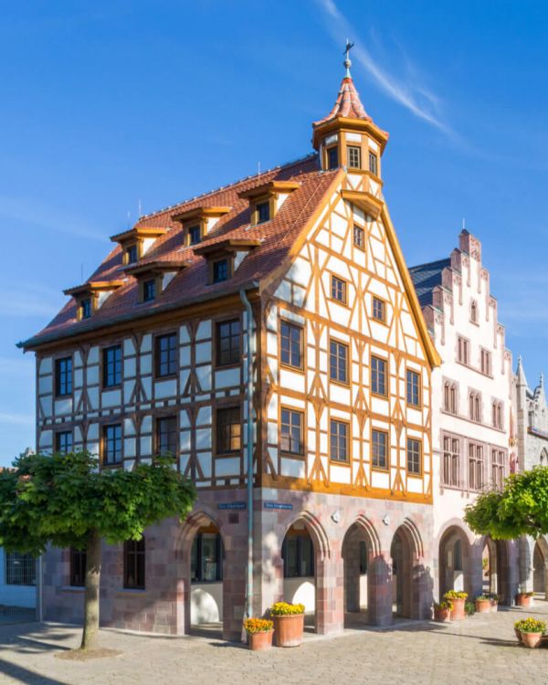 Das Pilatushaus aus Nürnberg seitlich. Es hat am Giebel einen Erker und ist im Fachwerkstil.