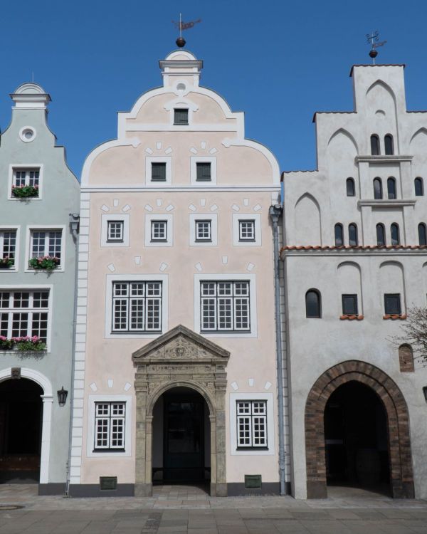 Die Drei Gebäude mit dem Namen die Drei Brüder aus Riga. Sie sind alle in hellen Farben.