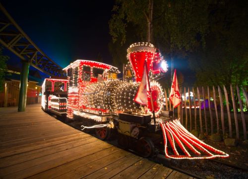 Der HANSA-PARK-Express am Bahnhof Peterhof. Der Zug wird im Dunkeln durch Lichterketten erleuchtet.