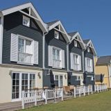 Die Häuser des Typus Hummer von außen. Sie sind entweder grau, gelb oder rot von außen.