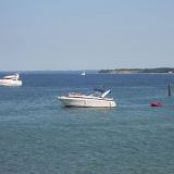Motorboote in der Ostsee. Sie liegen vor Anker. Im Hintergrund sieht man eine Steilküste.