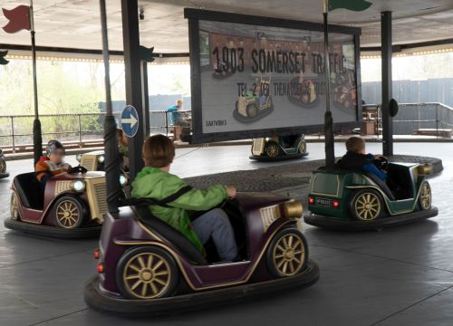 Verschiedene motorisierte Fahrzeuge fahren mit Kindern im Kreis