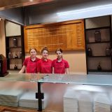 Drei junge Frauen in HANSA-PARK Arbeitskleidung hinter einem Tresen. Sie schauen in die Kamera.