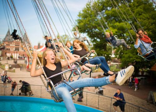 Gäste in den Sitzen des HANSE-Flieger. Sie lachen und halten sich an den Ketten fest.