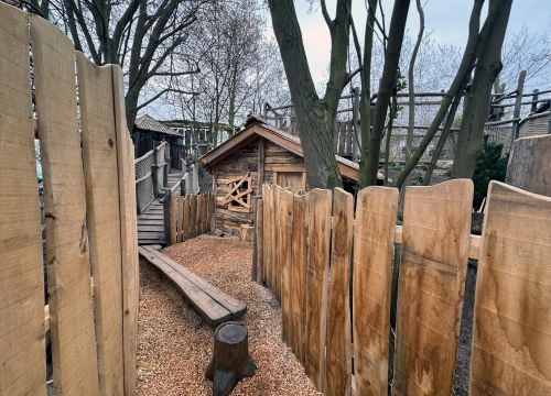 In der Attraktion Lost Trails of Roanoke steht eine Hütte vor der eine Axt im Baumstamm steckt.