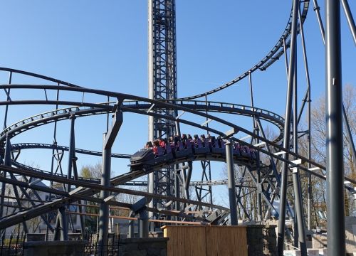 Die Achterbahn Nessie fährt in den Tunnel. Umliegend Schienen und der Turm des HIGHLANDER.
