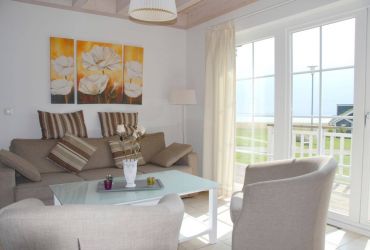 Couch mit zwei Sesseln und einen Couchtisch. Im Hintergrund ein Bild.