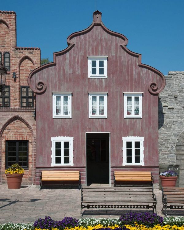 Das Gebäude Alter Gasthof von vorne. Es ist ein rotes Holz. Der Giebel ist geschwungen.