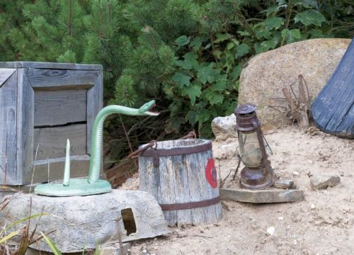 Ein Interaktives Ziel der Attraktion Pony-Post. Eine Schlange und ein Eimer mit einer Zielscheibe.