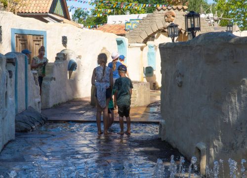 Auf dem Pfad Camino del Mar wollen Kinder den Wassergraben überqueren. Die Eltern stehen daneben.