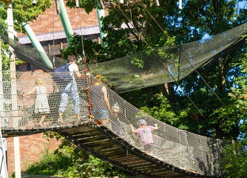 An der höchsten Stelle läuft eine Familie über die Hängebrücke im HANSA-PARK.