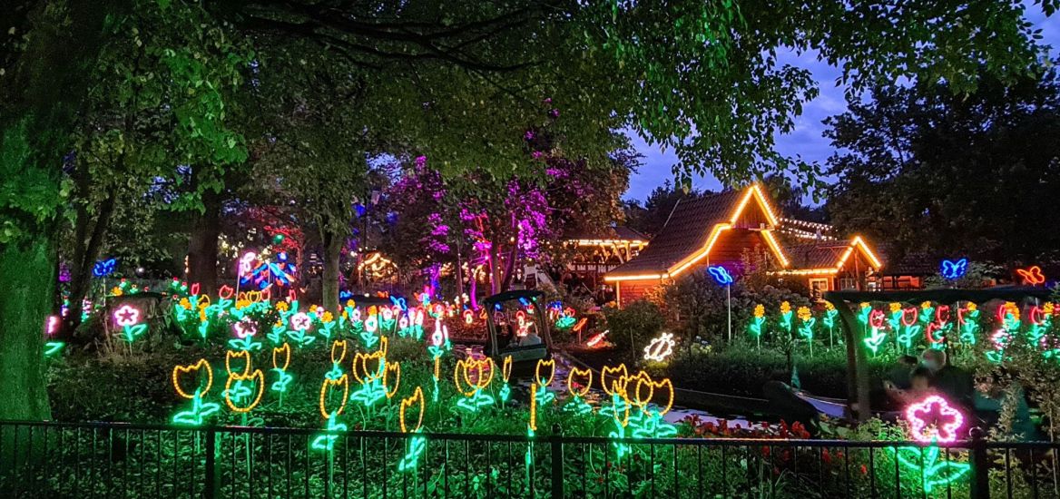 Die LED-Blumen der Blumenmeerbootsfahrt in der ersten Kurve. Boote fahren vorbei.