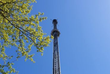 Der HIGHLANDER im Zentrum. Die Gondel ist weit oben beim Turm. Ein Baum im linken Drittel zu sehen.