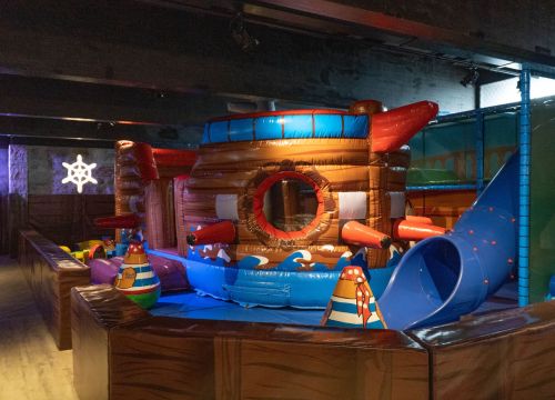 Im Piratencamp gibt es ein Schiff zum Klettern, dass mit Luft gefüllt ist. Daneben ist eine Rutsche.