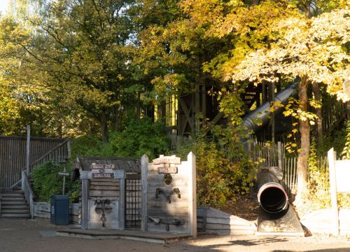 Eine Rutsche mit Turm. Daneben Pranger.