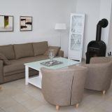 Couch mit zwei Sesseln und einen Couchtisch. Im Hintergrund ein Schrank und ein Kamin.