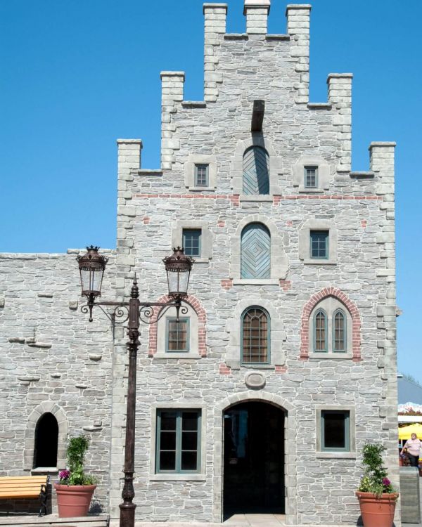 Im Fokus ist die Alte Apotheke. Es ist ein graues Steingebäude, dass einen Treppengiebel hat.