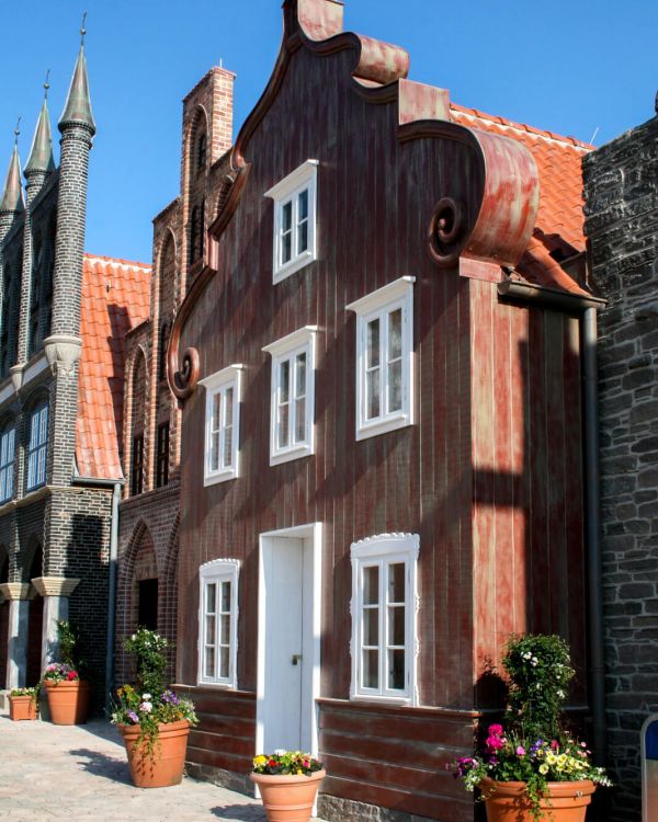 Das Gebäude Alter Gasthof von der Seite. Davor stehen Blumen in Blumentöpfen.