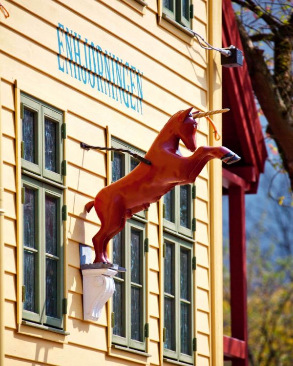 Am Gebäude Enhjorningen ist eine Einhorn Figur befestigt. Es hat ein goldenes Horn und steigt.