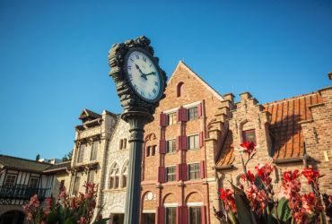 Im Vordergrund befindet eine verzierte Uhr. Im Hintergrund befinden sich hanseatische Arkaden.