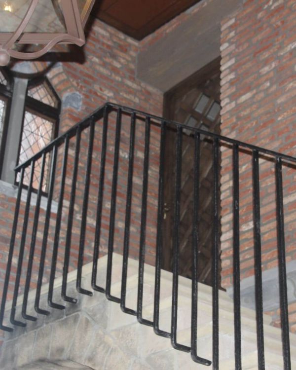 Eine Treppe die nach oben führt. Eine verschlossene Holztür mit vier kleine Fenstern.