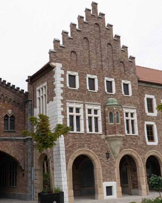Das Gebäude Muzeum Uniwersytetu aus Polen. Mit kleinem Erker vorne und weißem Rahmen um Fenster.