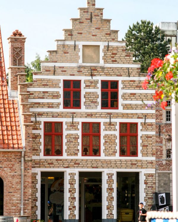 Die Außenansicht des Gebäudes vom Grote Markt in Brügge. Es hat rote Fensterrahmen.